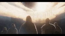 a group of people are standing in front of a large light coming out of the sky