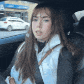 a woman is sitting in the back seat of a car wearing a seat belt