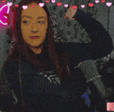 a woman flexing her muscles in front of a microphone with hearts around her
