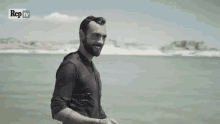 a man in a suit is swimming in the ocean with rep tv in the background .