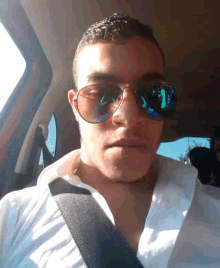 a man wearing sunglasses and a white shirt has the number 1 reflected in his sunglasses