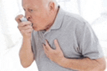 an elderly man is coughing while holding his chest .