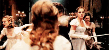 a group of women in white dresses are standing next to each other in a room .