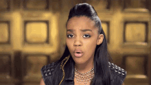 a young woman wearing a necklace and a leather jacket