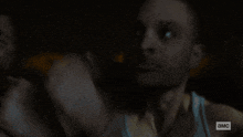 a man in a dark room says wait in a blurred image
