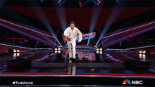 a man is dancing on a stage with the word nbc in the background