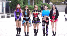 a group of girls are standing next to each other in front of a building with dispatch written on the bottom