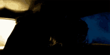 a man and woman are kissing in the dark