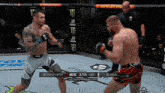 two men are fighting in a ufc ring with a monster energy sign in the background .