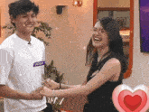 a boy with the name josh on his shirt is holding a woman 's hand