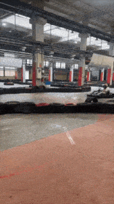 a go kart track in a warehouse with a red exit sign