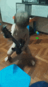 a little boy is playing a guitar in a room .
