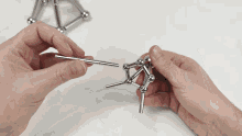 a person is holding a metal ball in their hand and playing with it