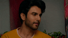 a close up of a man 's face in front of a painting of a woman
