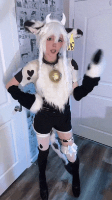 a girl in a cow costume stands in front of a door with a yellow tag that says 106