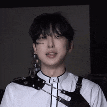 a close up of a person wearing a white shirt and a black harness