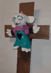 a cross with a stuffed animal on it