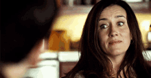 a woman with a surprised look on her face looks at a man