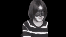 a person wearing a black and white striped shirt and a black mask