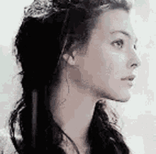 a close up of a woman 's face with her hair in a ponytail .