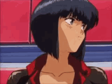 a girl with short black hair is wearing a red jacket and looking at the camera .