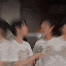 a blurry picture of a group of people standing next to each other in a room .