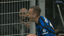 two soccer players are celebrating a goal with a cbs sports logo behind them
