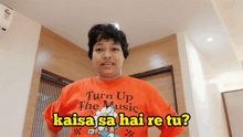 a woman is wearing an orange shirt that says turn up the music