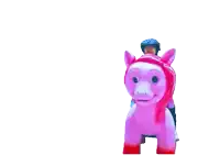 a woman is riding a pink pony with a helmet on her head