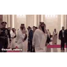 a group of men are walking on a red carpet with saudi_rulers written on the bottom