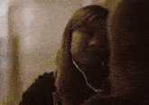 a young girl wearing headphones is looking at another girl .