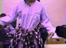 a woman wearing a polka dot shirt and plaid skirt