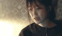 a woman is wearing headphones and crying while looking down