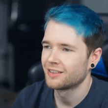 a man with blue hair and a beard is smiling