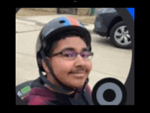a boy wearing a helmet and glasses is smiling
