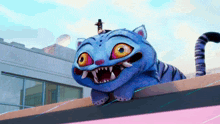 a blue cartoon cat with sharp teeth is laying on a ledge
