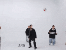 a group of people are playing volleyball in a large room