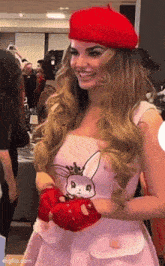 a woman wearing a red beret and a pink dress with a bunny on it .