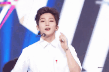 a young man wearing a white shirt with a red heart on the collar