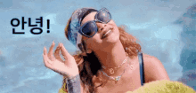 a woman wearing sunglasses , a headband and a necklace is standing in a pool .