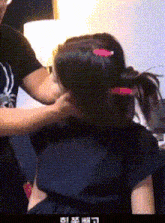 a man is putting a pink hair clip in a girl 's hair .