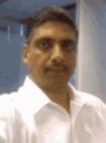 a man wearing a white shirt takes a selfie
