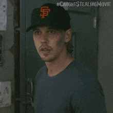 a man wearing a san francisco giants baseball cap stands in front of a door