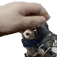 a person is petting a stuffed animal with a bandana around its mouth .