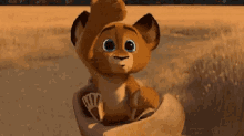 a cartoon lion is sitting in a person 's hand .