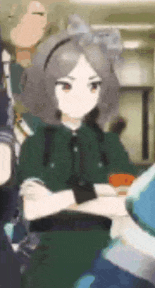a girl with gray hair is standing with her arms crossed in a room with other people .