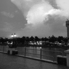 a black and white photo of a river with a building in the background that says ' saigon tower ' on it