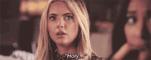 a close up of a woman 's face with the words `` holy '' written next to her .