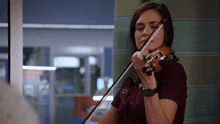 a woman wearing a watch is playing a violin in a hospital