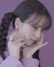 a woman with purple nails and a braided ponytail